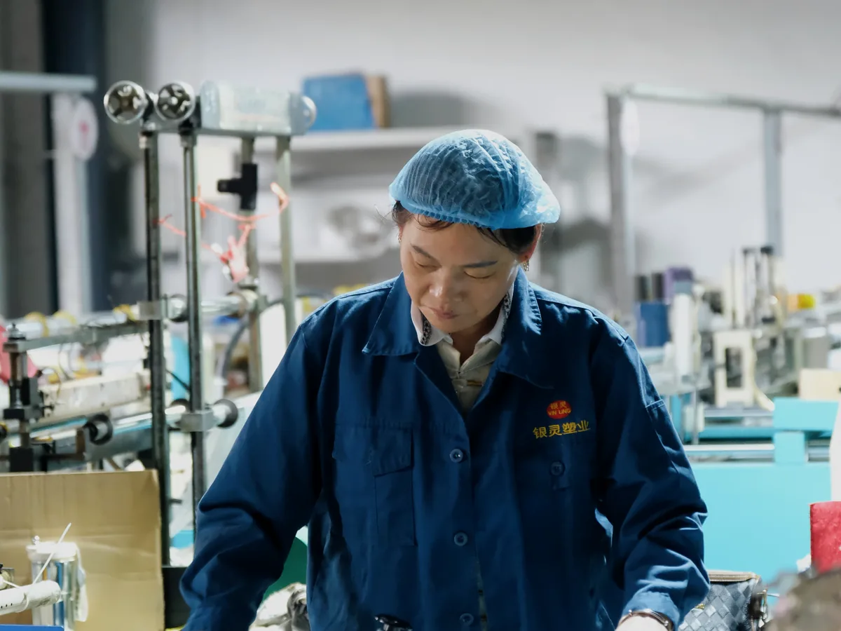 Yinling worker inspecting finished plastic bags during production