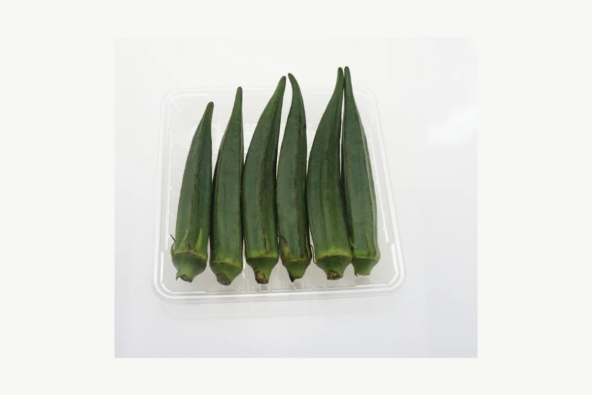 Complete shallow clear produce tray holding okra