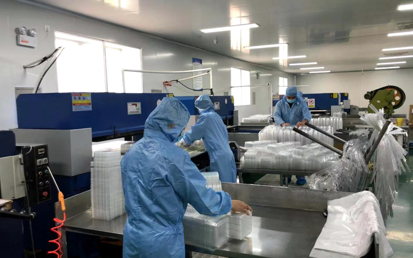 Yinling staff handling nested clear plastic food containers in the workshop
